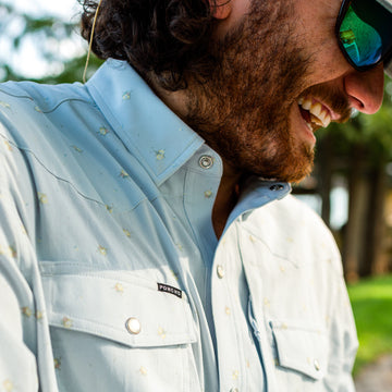 man smiling in blue floral shirt