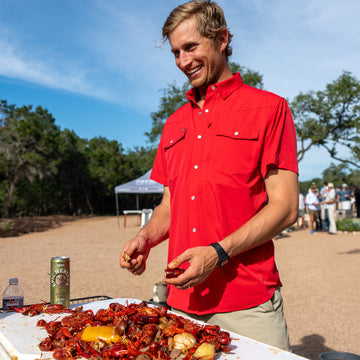 man smiling with crawfish wearing red shirt