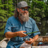 Man fishing on a boat wearing The Ahi breathable outdoor shirt and sunglasses