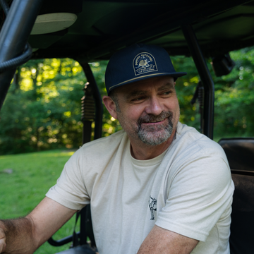 Man smiling while looking out of a side by side