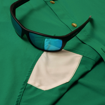 sunglasses with lens cleaner on green shirt