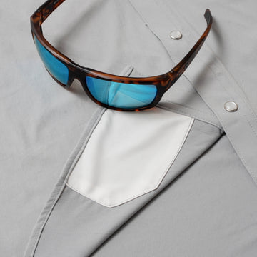sunglasses with lens cleaner on grey shirt