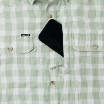 Close-up of green plaid button-up shirt with chest pockets and a phone partially tucked inside, featuring The Sapelo label.