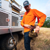 man putting shells in belt wearing long sleeve blaze orange shirt
