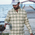 man wearing green and white plaid flannel holding cup