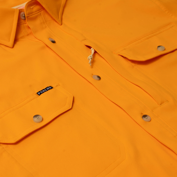 Close-up of bright orange button-up shirt with front pockets showcasing The First and Goal design