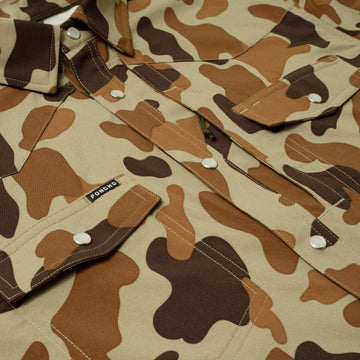 Close-up of The White Wing camo outdoor shirt with snap button pockets and Poncho label