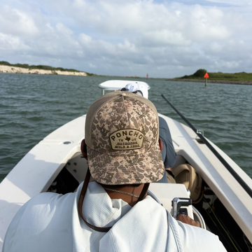 man driving skiff wearing the game hat