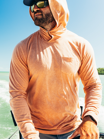 Mann in orange hoodie on a boat