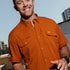 Man wearing The San Jacinto rust-colored outdoor shirt holding a football outdoors