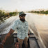 Man wearing The Chicken on a Hook shirt on a boat ride through a swamp at sunset