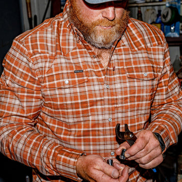 man holding wrench wearing monte vista flannel
