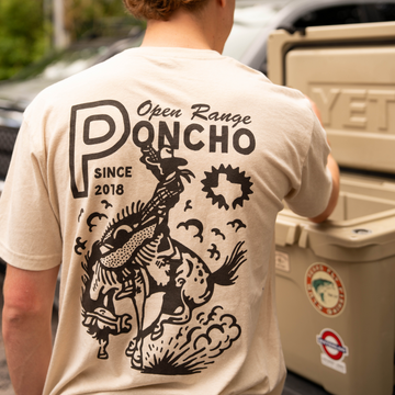 man wearing the open range tee grabbing drink