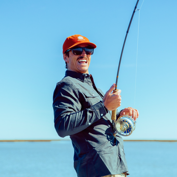 man holding fishing rod with orange agave hat