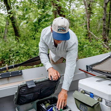 Man loading up boat with tackle boxes.