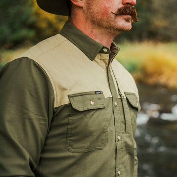 Close-up of man wearing The Roosevelt comfortable outdoor shirt in green and beige with front pockets and button details