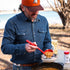 Man wearing The Sanderson denim outdoor shirt serving stew outdoors by a lake