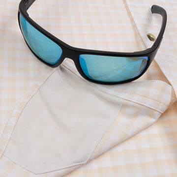 Closeup of sunglasses with lens cleaner on shirt