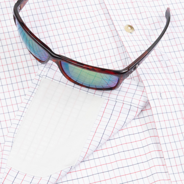 Closeup of sunglasses with lens cleaner on shirt