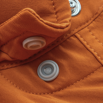 Close-up of orange fabric with snap buttons on The 1969 shirt