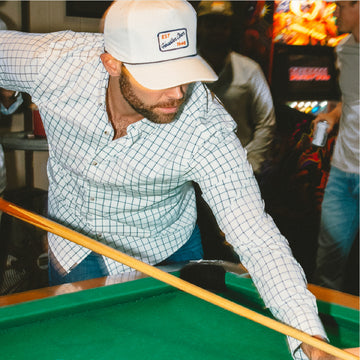 man shooting pool wearing the abaco shirt