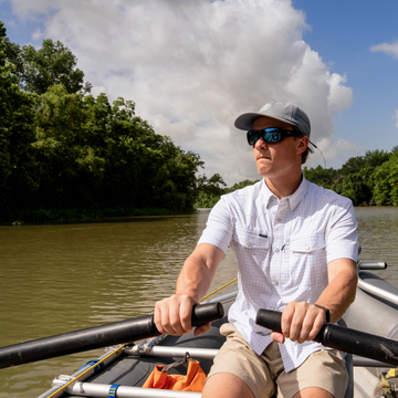 Man rowing a raft while wearing The Auctioneer