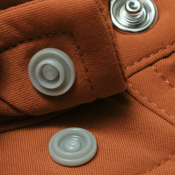 Close-up of rust-colored fabric with snap buttons on The Bertha shirt