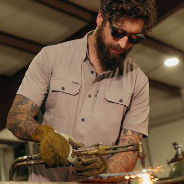 Man cutting metal while wearing the Big Iron shirt