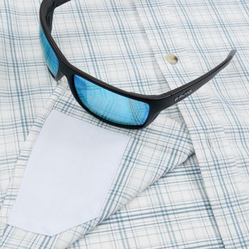 Closeup of sunglasses with lens cleaner on shirt
