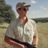 man wearing the brown bear shirt holding shotgun