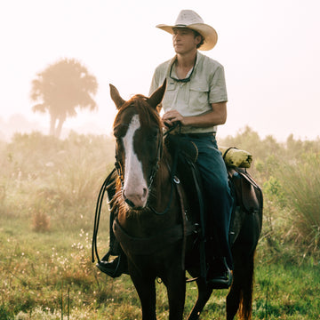 man riding a horse while wearing The Buckskin