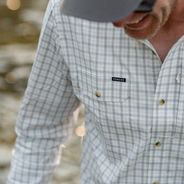 Man outdoors wearing The Buffalo Ford plaid shirt with a front pocket logo