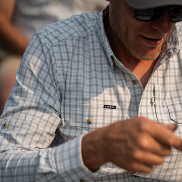 Man wearing The Buffalo Ford shirt from Poncho Outdoors in a light plaid pattern outdoors
