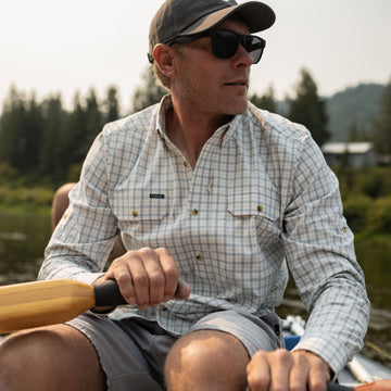Man wearing The Buffalo Ford shirt rowing a boat outdoors