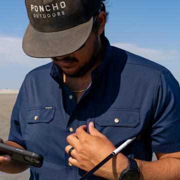 Man putting a phone in the zipper pocket on shirt