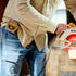 Close-up of person wearing The Carpenter shirt using a circular saw on wood outdoors