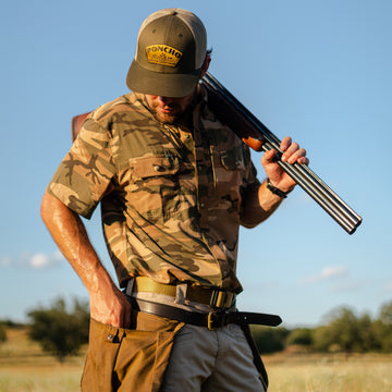 Man wearing The Cordoba camouflage shirt holding a shotgun outdoors