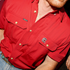 Red shirt featuring The Gamecock logo on chest pocket and poncho label on opposite pocket