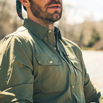 The Gunnison outdoors shirt in olive green worn by a man near a river