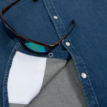 Close-up of The Harris blue outdoor shirt with snap buttons and sunglasses resting on top