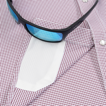 Closeup of sunglasses with lens cleaner on shirt
