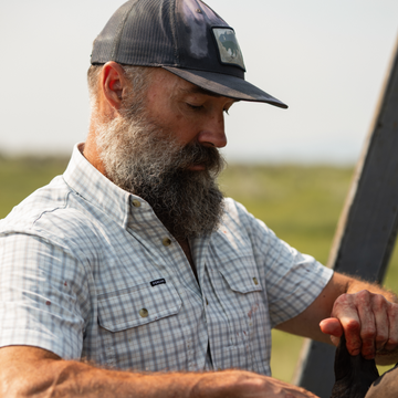Man wearing The Lamar Valley shirt outdoors with a cap and beard