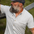 Man wearing The Lamar Valley shirt outdoors leaning on a fence rail