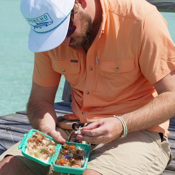 man wearing mexican sunset shirt grabbing fly