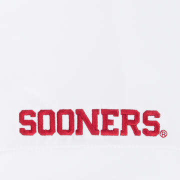 Close-up of red embroidered Sooners logo on white fabric of The Oklahoma shirt