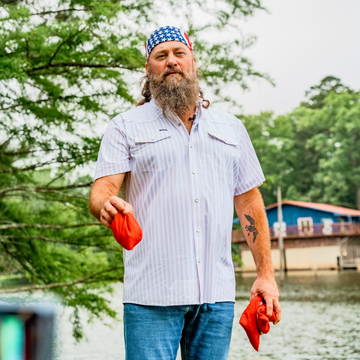 man with wearing the old glory shirt with cornhole bags