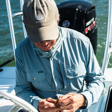 man tying on fly wearing the paul dixon shirt