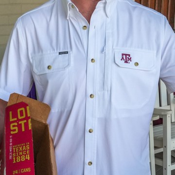 Close-up of a white "The Reveille" shirt with snap buttons and branded chest pockets