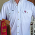 Close-up of a white "The Reveille" shirt with snap buttons and branded chest pockets