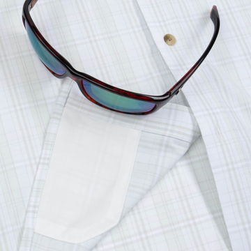 Closeup of sunglasses with lens cleaner on shirt